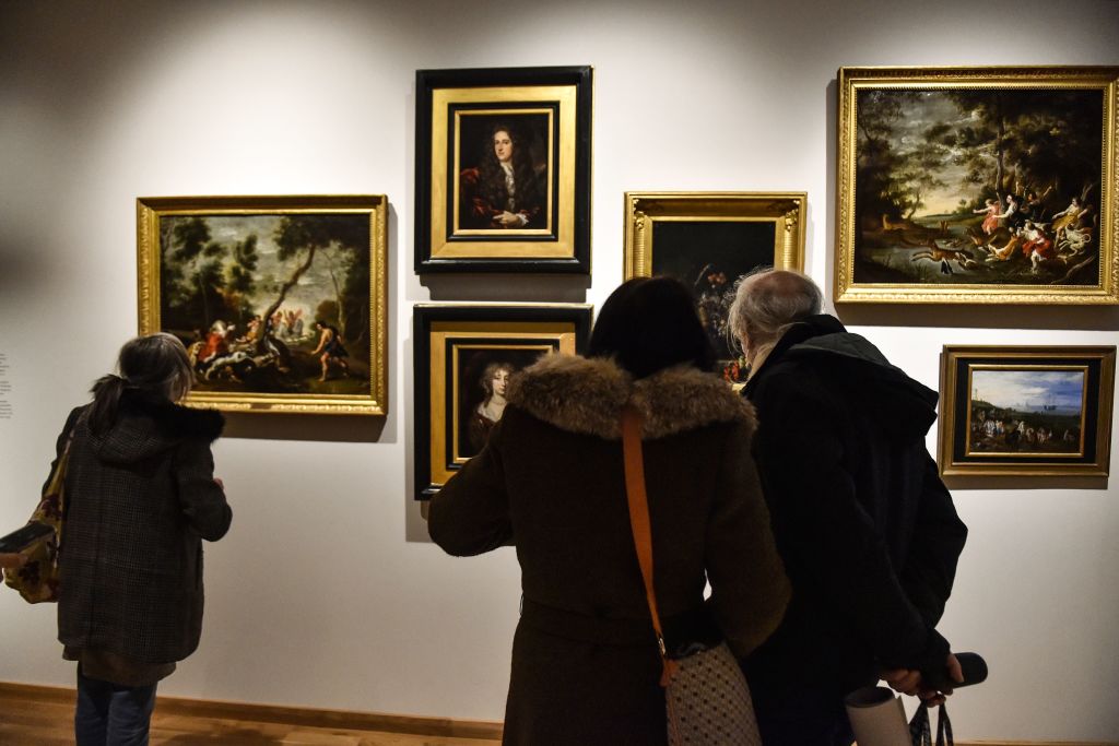 People visit the exhibition "Portraits de reines de France" at the Hyacinthe-Rigaud art museum in Perpignan on February 9, Photo by Raymond Roig/AFP via Getty Images.