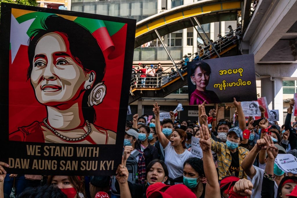 Protesters make three-finger salutes and hold up banners and posters as they march on February 08, 2021 in downtown Yangon, Myanmar. Photo by Stringer/Getty Images.