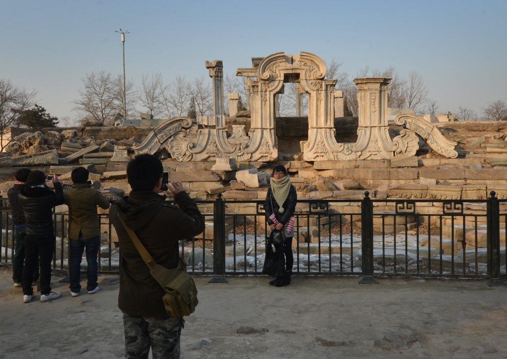 A woman poses for photos at the ruins of the historic Jesuit designed Yuanying Guan (Immense Ocean Observatory) at the Old Summer Palace in Beijing on January 6, 2013. The Old Summer Palace, commissioned by the Chinese Emperor Qianlong and designed by Jesuit priests in a European style, was destroyed in 1860 by Anglo-French forces during the second Opium War. Photo by Mark Ralston/AFP via Getty Images.