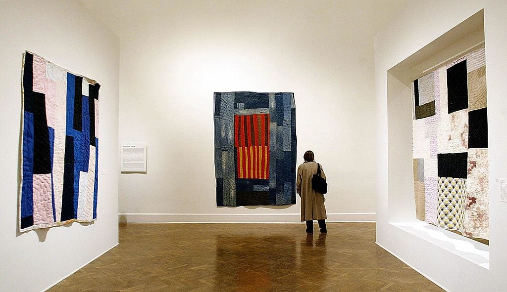 A visitor looks at "The Quilts of Gee's Bend," a show at the Corcoran Gallery of Art in Washington, DC, in February 2004. (Photo credit should read STEPHEN JAFFE/AFP via Getty Images)