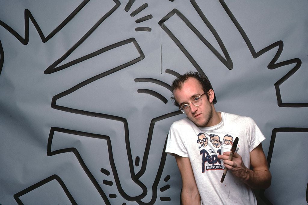 Keith Haring photographed with one of his paintings