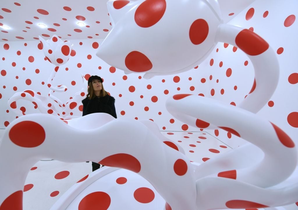 A woman looks at the art of Yayoi Kusama at the David Zwirner Gallery in New York. Photo: TIMOTHY A. CLARY/AFP via Getty Images.