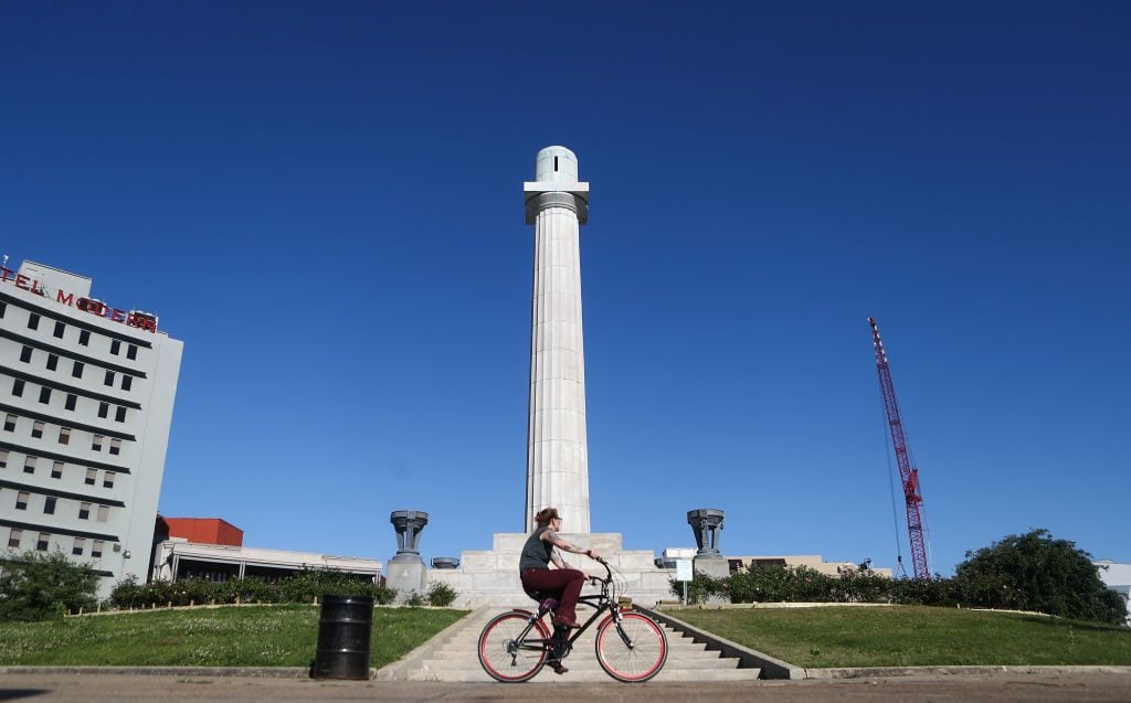 A woman bikes past the pedestal in New orleans that once held Confederate General Robert E. Lee's statue, which was removed in 2017 amidst controversy. Photo: Mario Tama/Getty Images.