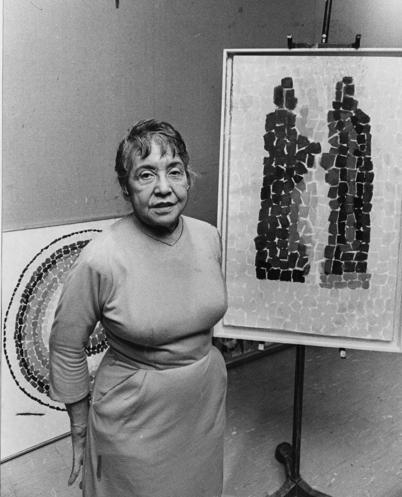 Alma Thomas shown with two of her paintings that were part of an exhibition of her work at Howard University Art Gallery in Washington, DC, on April 20, 1966. (Photo by Ellsworth Davis/The Washington Post via Getty Images)