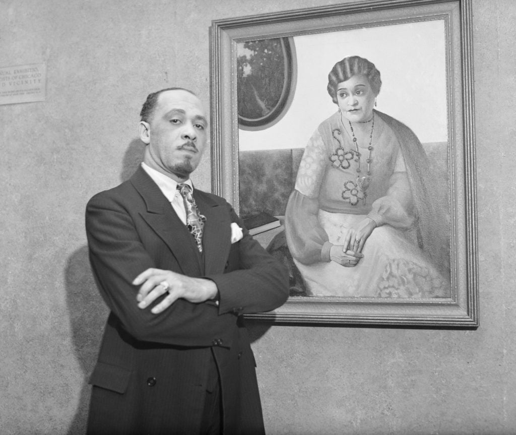 Archibald J. Motley, Jr., with one of his paintings, at the Chicago Artists' show at the Art Institute. (Image courtesy Getty Images.)
