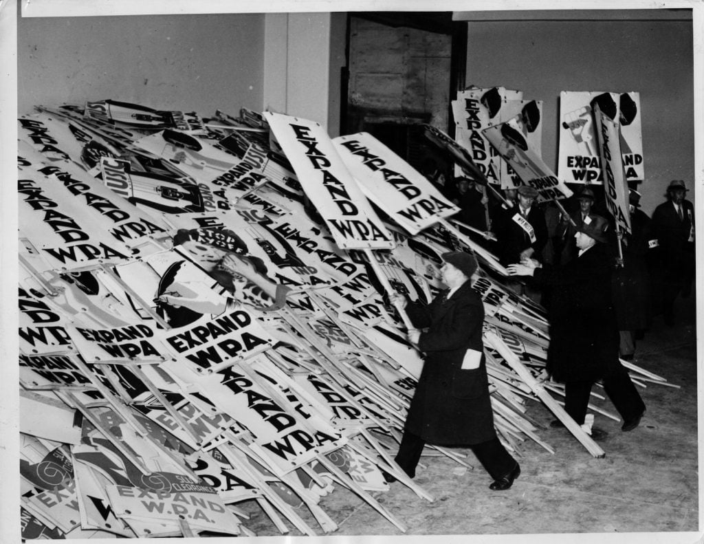 A crowd protests the curtailment of the WPA and piles picket signs outside Madison Square Garden. (Photo by Hulton-Deutsch/Hulton-Deutsch Collection/Corbis via Getty Images)