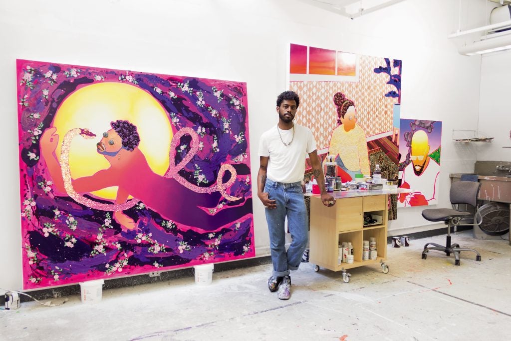 Devan Shimoyama in front of two vibrant works in progress in his Pittsburgh studio, located on the Carnegie Mellon University campus. Photo by Sunny Leerasanthanah, ©2021 Jasmin Hernandez.