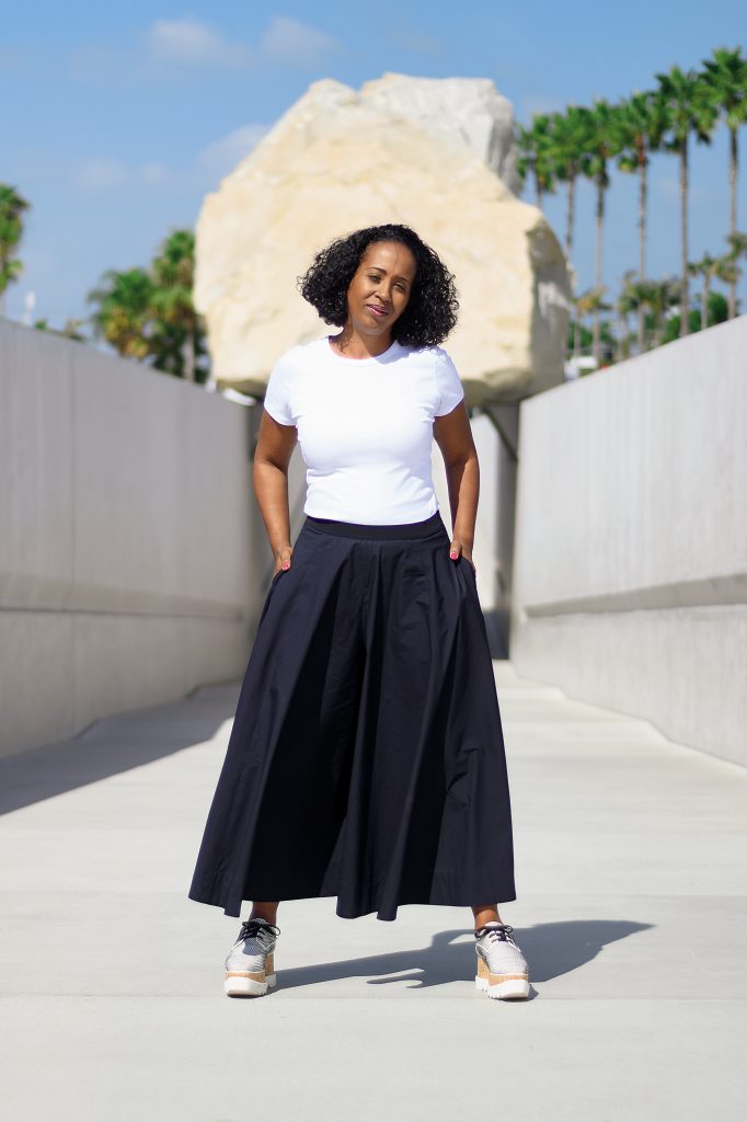 Naima J. Keith stands in front of <em>Levitated Mass</em>, a large-scale public art sculpture by Michael Heizer at LACMA. Photo by Jasmine Durhal, ©2021 Jasmin Hernandez.