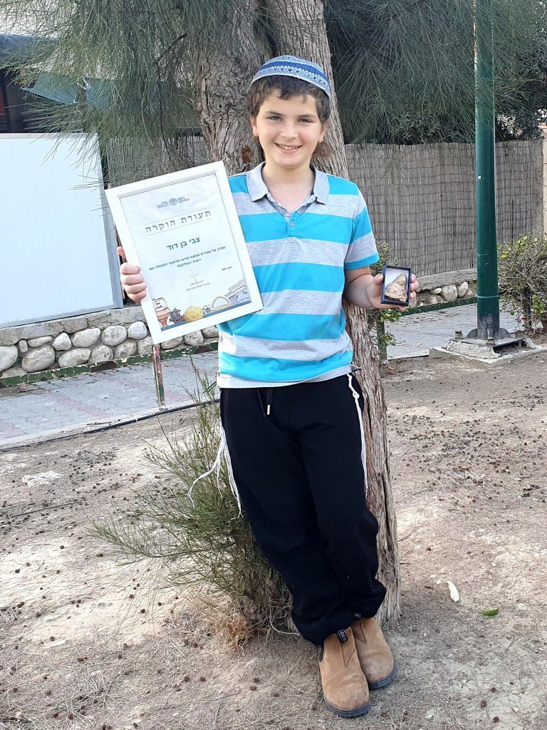 11-year-old Zvi Ben-David with the ancient figurine. Courtesy of the Israel Antiquities Authority.