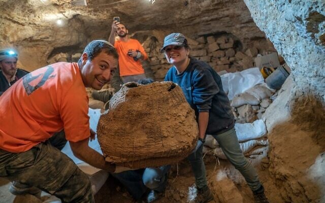Archaeologists Chaim Cohen and Naama Sukenik with the world’s oldest basket, as found in Muraba‘at Cave. Photo by Yaniv Berman, courtesy of the Israel Antiquities Authority.