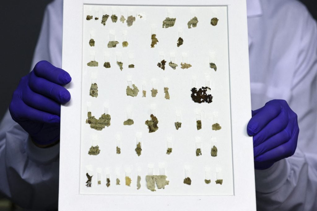 Israel Antiquities Authority conservator Tanya Bitler displays recently-discovered 2000-year-old biblical scroll fragments from the Bar Kochba period, after completion of preservation work at the authority's Dead Sea conservation lab in Jerusalem. Photo by Menahem Kahana/AFP via Getty Images.