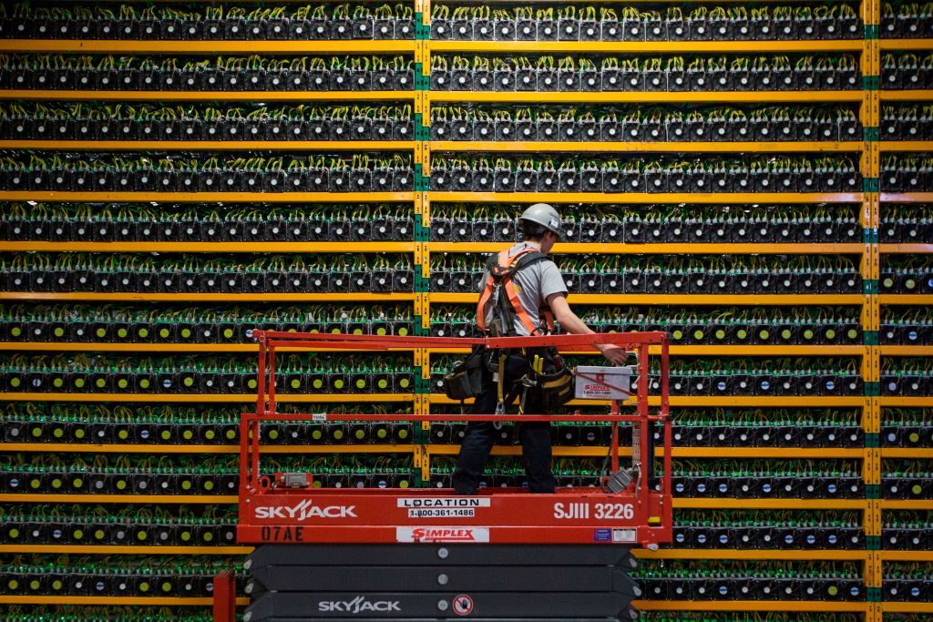 A technician inspects the backside of bitcoin mining at Bitfarms in Saint Hyacinthe, Quebec on March 19, 2018. Photo by Lars Hagberg/AFP via Getty Images.