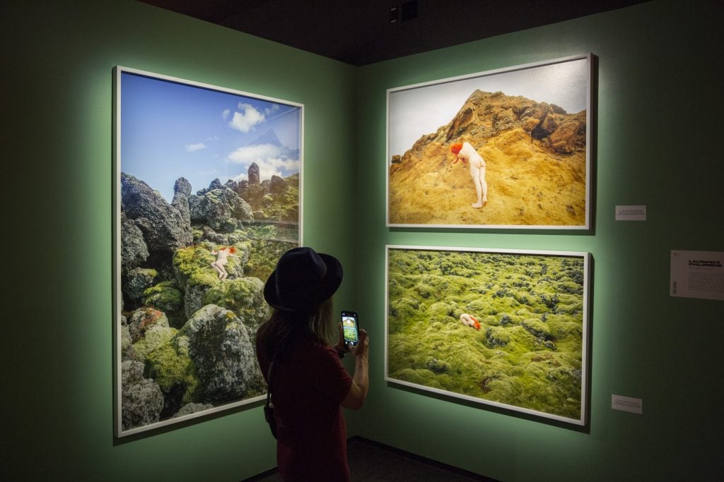 A visitor looking at photographs in a gallery at Fotografiska New York. Courtesy of CultureWorks. Photo: Roman Dean.