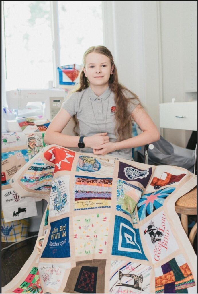 Madeleine Fugate with the COVID Memorial Quilt. Photo courtesy of the artist.