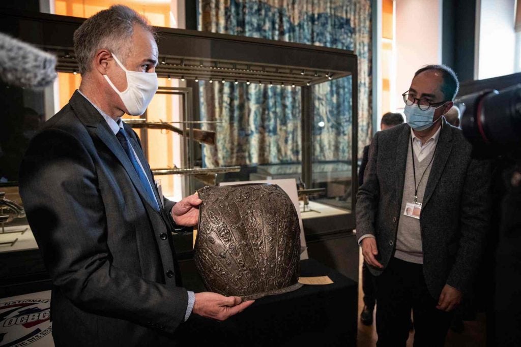 Frederic Malon (left), deputy director in charge of the fight against organized crime at the French Central Directorate of the Judicial Police (DCPJ), officialy returns an ancient breastplate to Jean-Luc Martinez (right), president of the Louvre Museum, in Paris, on March 3, 2021. (Photo by Thomas Samson/AFP via Getty Images)