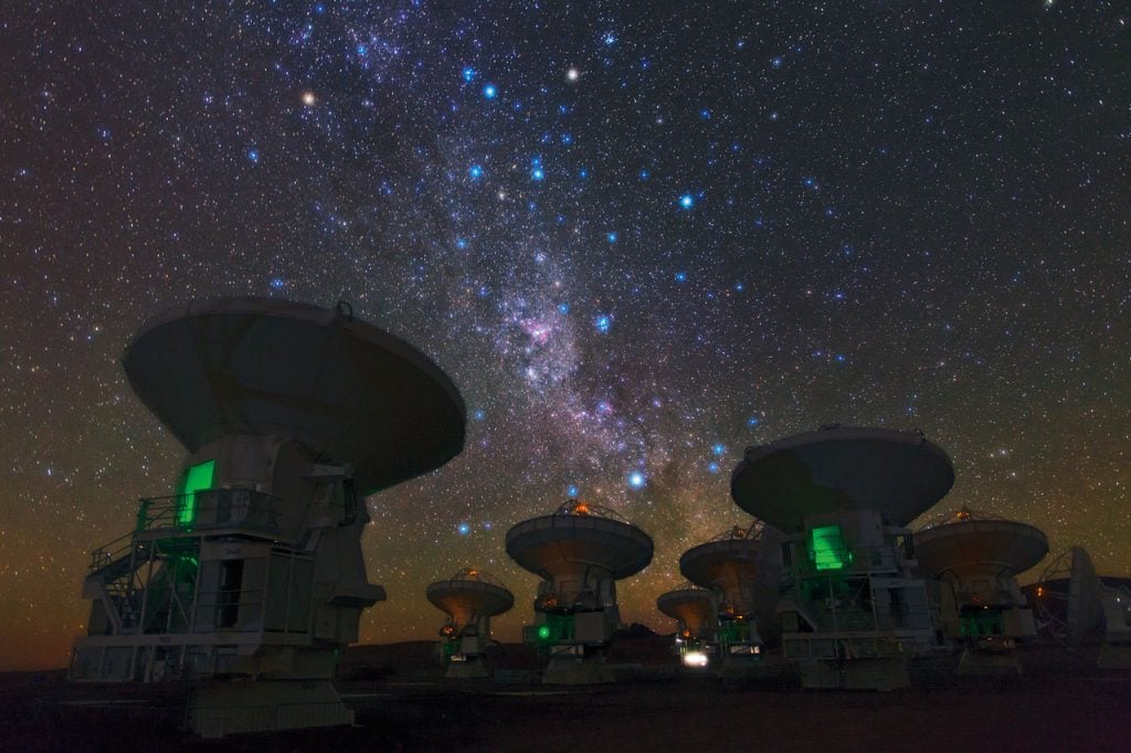 The Atacama Large Millimeter/submillimeter Array (ALMA), part of the Event Horizon Telescope Collaboration, set against the Milky Way. Photo by European Southern Observatory Photo Ambassador Babak Tafreshi.