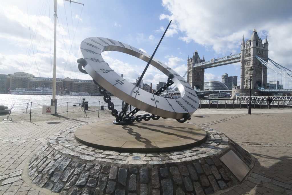 Wendy Taylor, Timepiece (1973) at St. Katherine's Dock, London, with a view of the River Thames and Tower Bridge behind. Photo by Then and Now Images/Heritage Images/Getty Images.