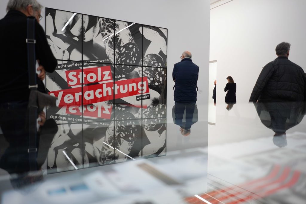 Visitors to the Hamburger Bahnhof Museum pass by a work by the artist Barbara Kruger in part of a show works from the Friedrich Christian Flick Collection. Photo: Jörg Carstensen/dpa. Photo: Jörg Carstensen/picture alliance via Getty Images.