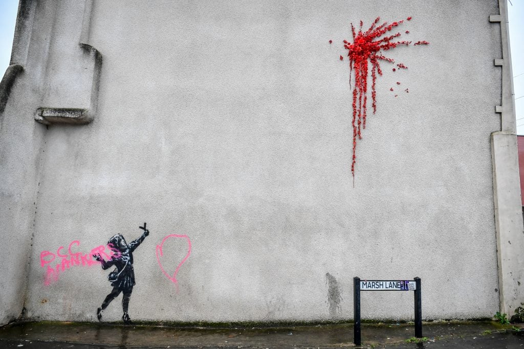 A Banksy work of art on the side of a house on Marsh Lane, Barton Hill, Bristol, was vandalized with pink spray paint the day after it was unveiled on Valentine's Day. Photo by Ben Birchall/PA Images via Getty Images.