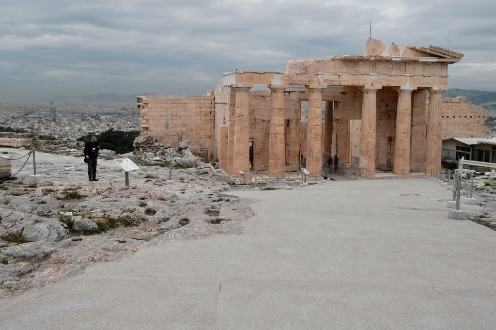 A person stands next to the new path for disabled people in front of the Propylaia at the Acropolis Archaeological site, in Athens, on December 3, 2020. Photo by Louisa Gouliamaki / AFP via Getty Images.