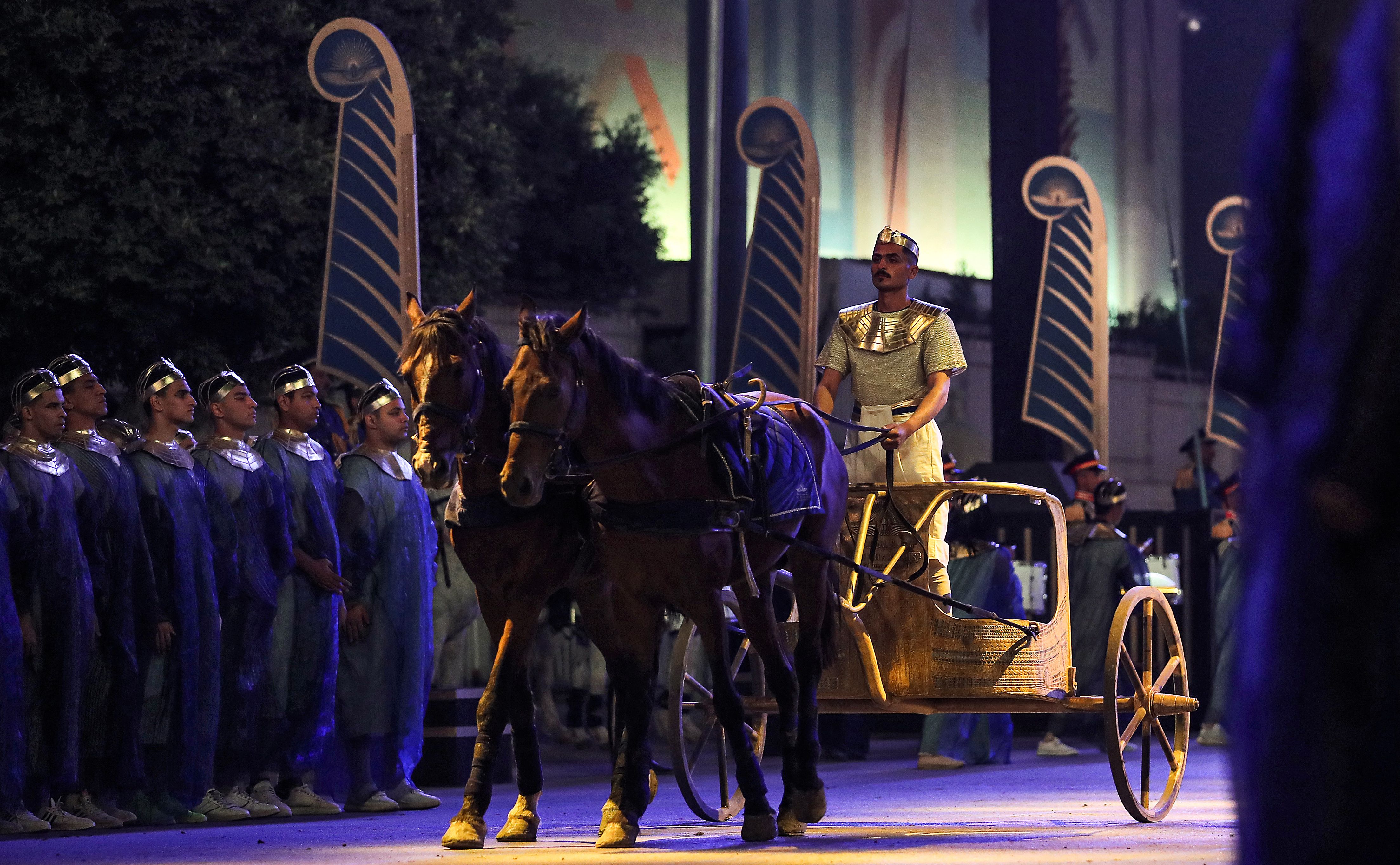 A performer rides a two-horse chariot at the start of the parade of 22 ancient Egyptian royal mummies departing from the Egyptian Museum in Cairo's Tahrir Square on April 3, 2021, on their way to their new resting place at the new National Museum of Egyptian Civilization in the Pharaohs' Golden Parade. Photo by Mahmoud Khaled/AFP via Getty Images.