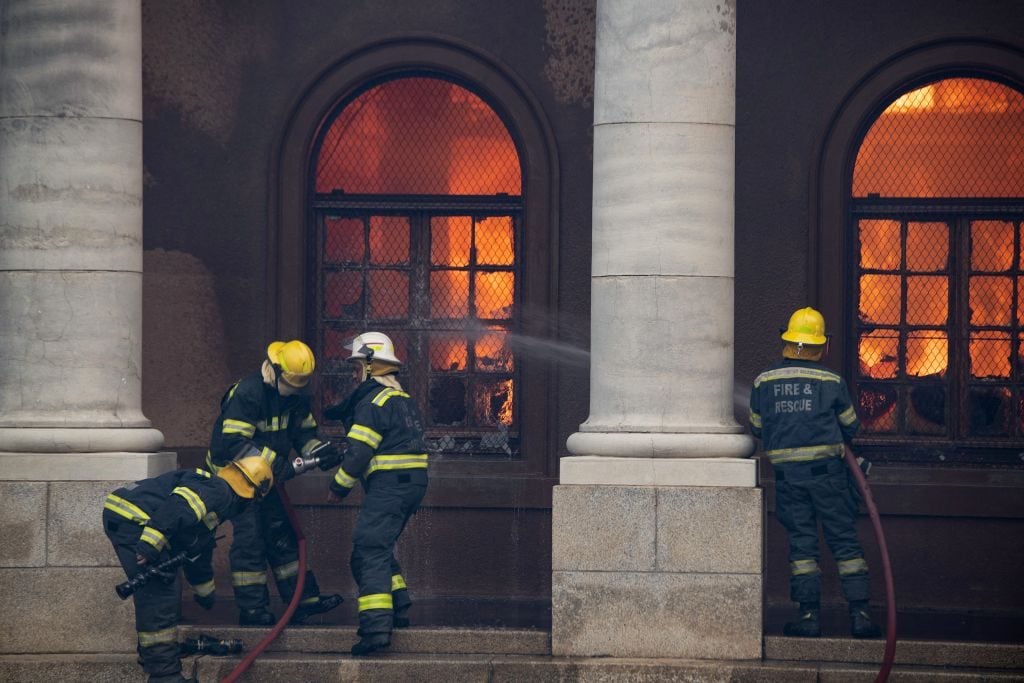 Firefighters try to extinguish a fire in the Jagger Library, at the University of Cape Town. Photo by RODGER BOSCH/AFP via Getty Images.