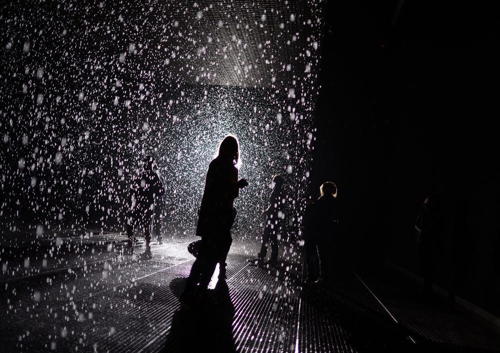 A visitor at Random International's "Rain Room" at MOMA (2012). Photo: TIMOTHY CLARY/AFP via Getty Images.