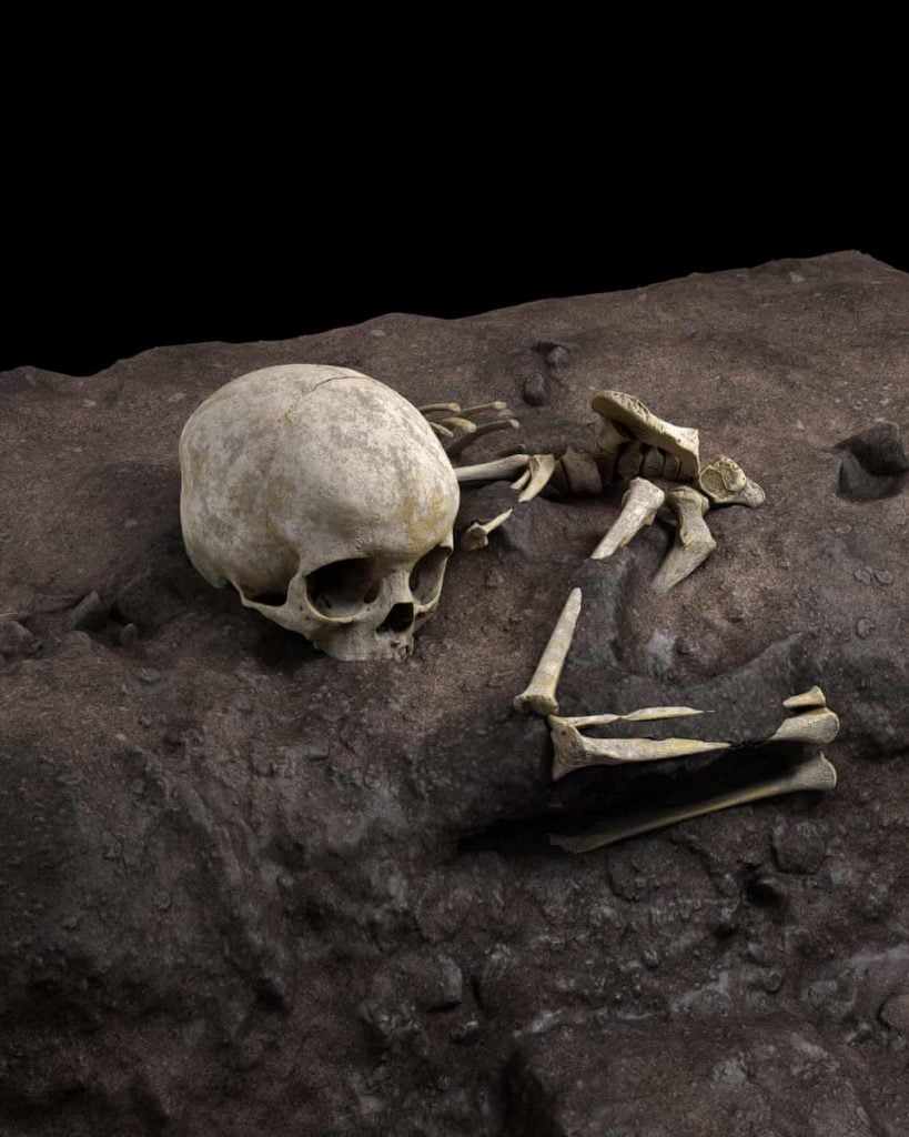 A rendering of the burial of Mtoto, the oldest-known grave in Africa, as the child was discovered in Panga ya Saidi cave. Image by Jorge González, University of South Florida, and Elena Santos, University Complutense of Madrid.