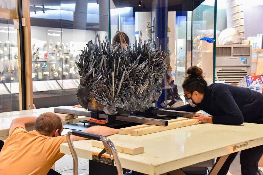 Exhibition staff members install a nearly-half-ton stibnite specimen in the all-new Halls of Gems and Minerals at the American Museum of Natural History. Photo by D. Finnin, ©American Museum of Natural History.
