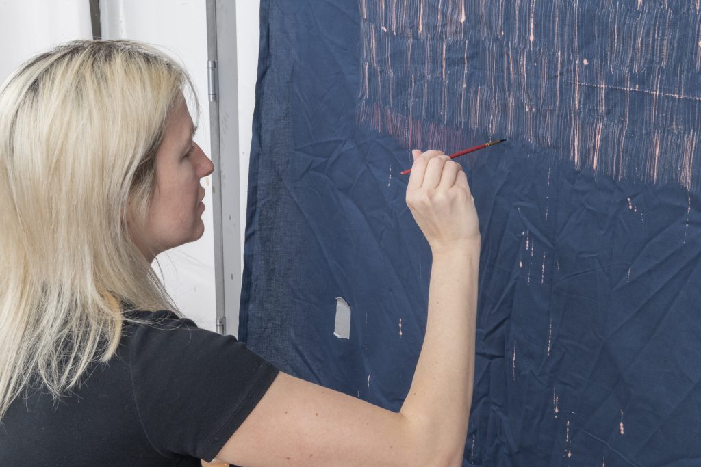 Natalie White working on her "Bleach Paintings" series. Photo by Adam Reich, courtesy of the artist. 