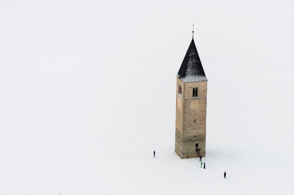 Frozen Lake Resia and the bell tower of Saint Catherine's Church in northern Italy, via Getty images.