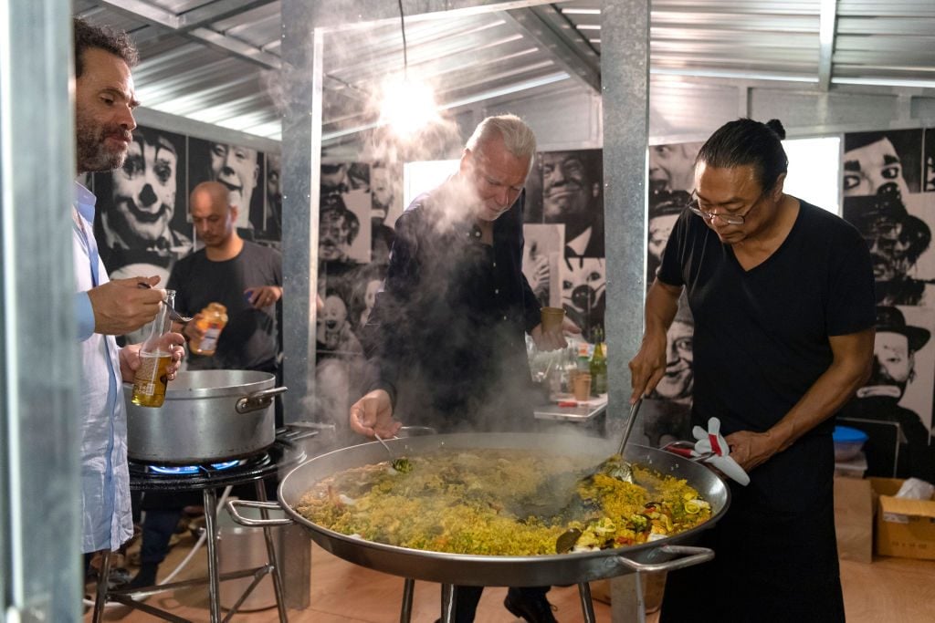 dealer Gavin Brown, dealer Patrick Seguin, and artist Rirkrit Tiravanija during a performanceon October 17, 2019 in Paris, France. (No, this is not pad thai, but at least it captures the vibe?) Photo by Luc Castel/Gettyimages