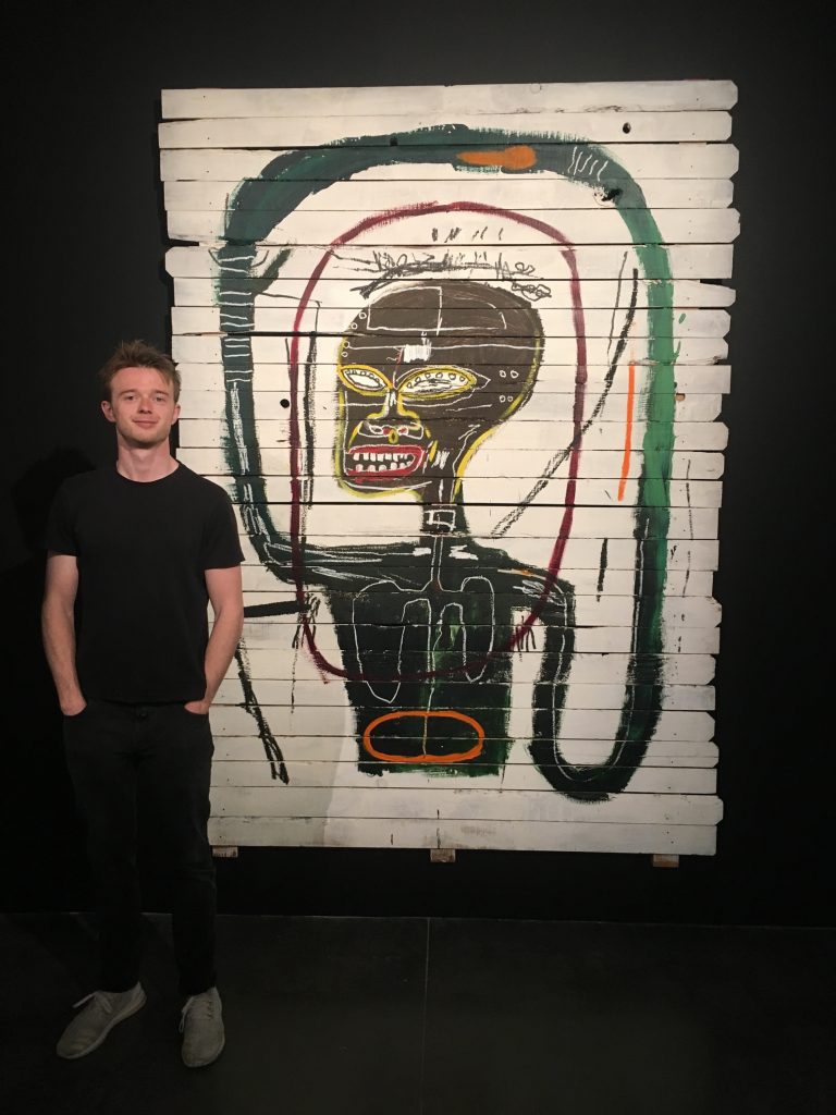 Connor Remes with a painting by Basquiat. Courtesy of Remes Advisory.