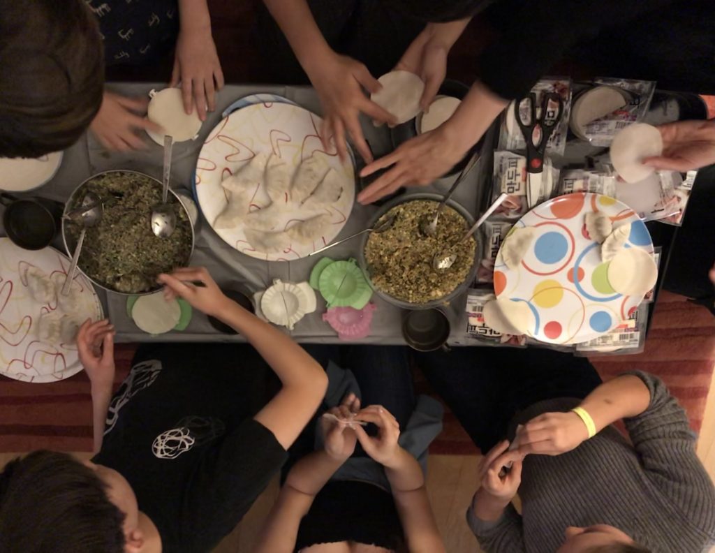 Many hands make light work when it comes to <em>mandu</em>, a traditional Korean dumpling that Jean Shin makes with family every New Year. Photo courtesy of Jean Shin. 