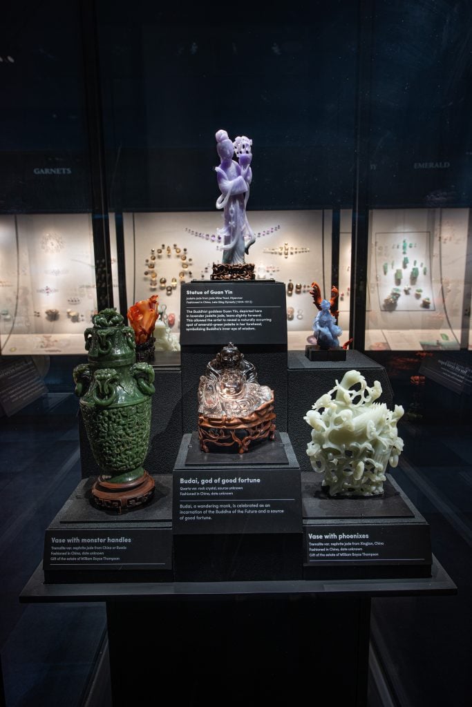 In addition to the Guan Yin statue (top), other carvings in the Gem Hall include, from left, a vase with monster handles made out of nephrite jade, Budai—a wandering monk celebrated as god of good fortune—made from quartz, and a vase with phoenixes made from nephrite jade. Photo by D. Finnin, ©American Museum of Natural History.