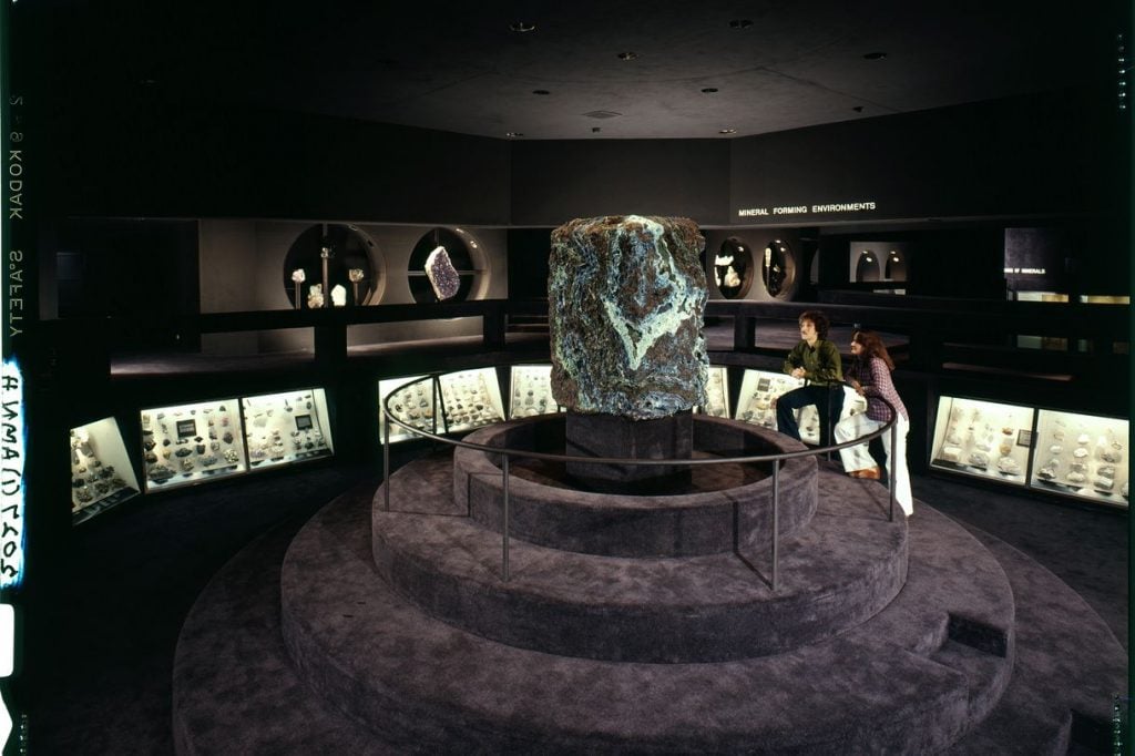 Visitors in Minerals Hall at the American Museum of Natural History (1976) examine the Singing Stone, a 4.5 ton block of vibrant blue azurite and green malachite from Arizona that hums with changes in humidity. The climate control in the new hall prevents this from happening. Photo courtesy of the American Museum of Natural History.