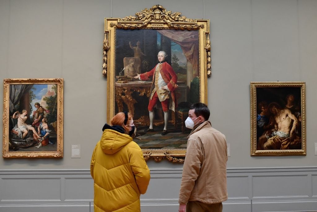 Visitors wearing facemasks look at paintings at The Metropolitan Museum of Art, 'The Met' in New York City on February 9, 2021. Photo by Angela Weiss / AFP via Getty Images.