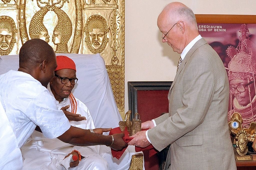 Retired hospital consultant Mark Walker (R) hands over two bronze artefacts he returned to the Benin kingdom to the Oba (King) of Benin, Uku Akpolokpolo Erediauwa I, during a ceremony in Benin City, Nigeria, on June 20, 2014. Photo: Kelvin Ikpea/AFP via Getty Images.