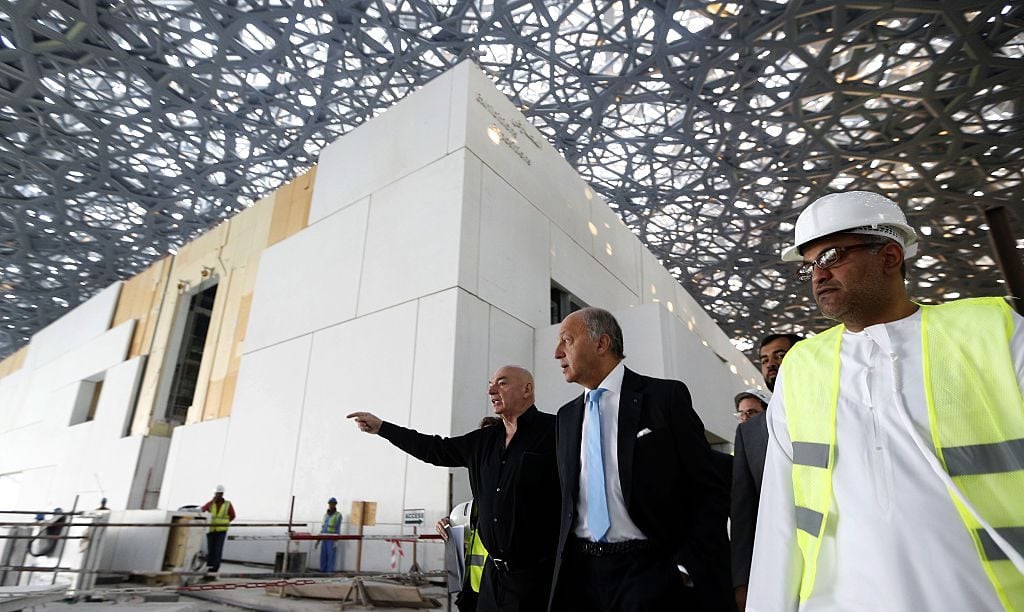 French Foreign Minister Laurent Fabius and French architect Jean Nouvel (L) visit the construction site of the future Louvre museum on Saadiyat island, outside the UAE capital Abu Dhabi on January 18, 2016. KARIM SAHIB/AFP via Getty Images.