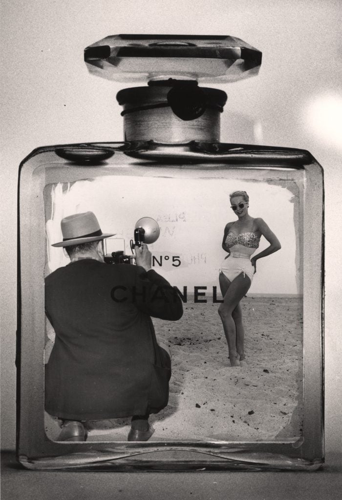 Photomontage of American photographer Weegee (1899 - 1968) taking a photograph of a woman in a bathing suit inside a Chanel No. 5 bottle in the late 1950s. (Photo by Weegee(Arthur Fellig)/International Center of Photography/Getty Images)