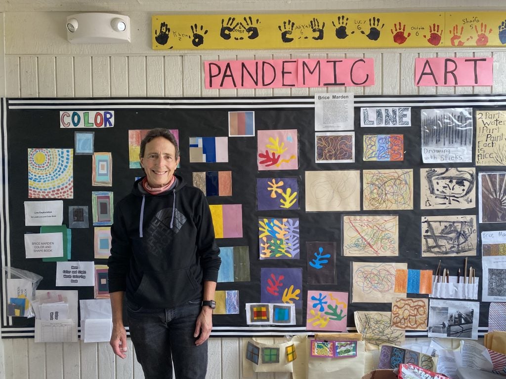 Ellen Oppenheimer with student artwork made during the pandemic. Photo by Sarah Cascone.