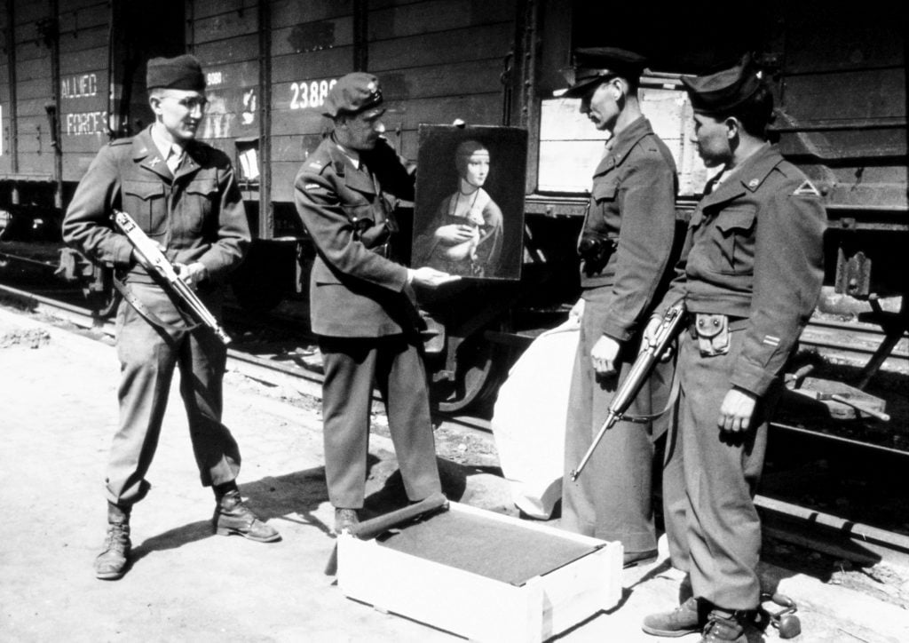 Monuments Men Lt. Frank P. Albright, Polish Liaison Officer Maj. Karol Estreicher, Monuments Man Capt. Everett Parker Lesley, and Pfc. Joe D. Espinosa, guard with the 34th Field Artillery Battalion, pose with Leonard da Vinci's Lady with an Ermineupon its return to Poland in April 1946.