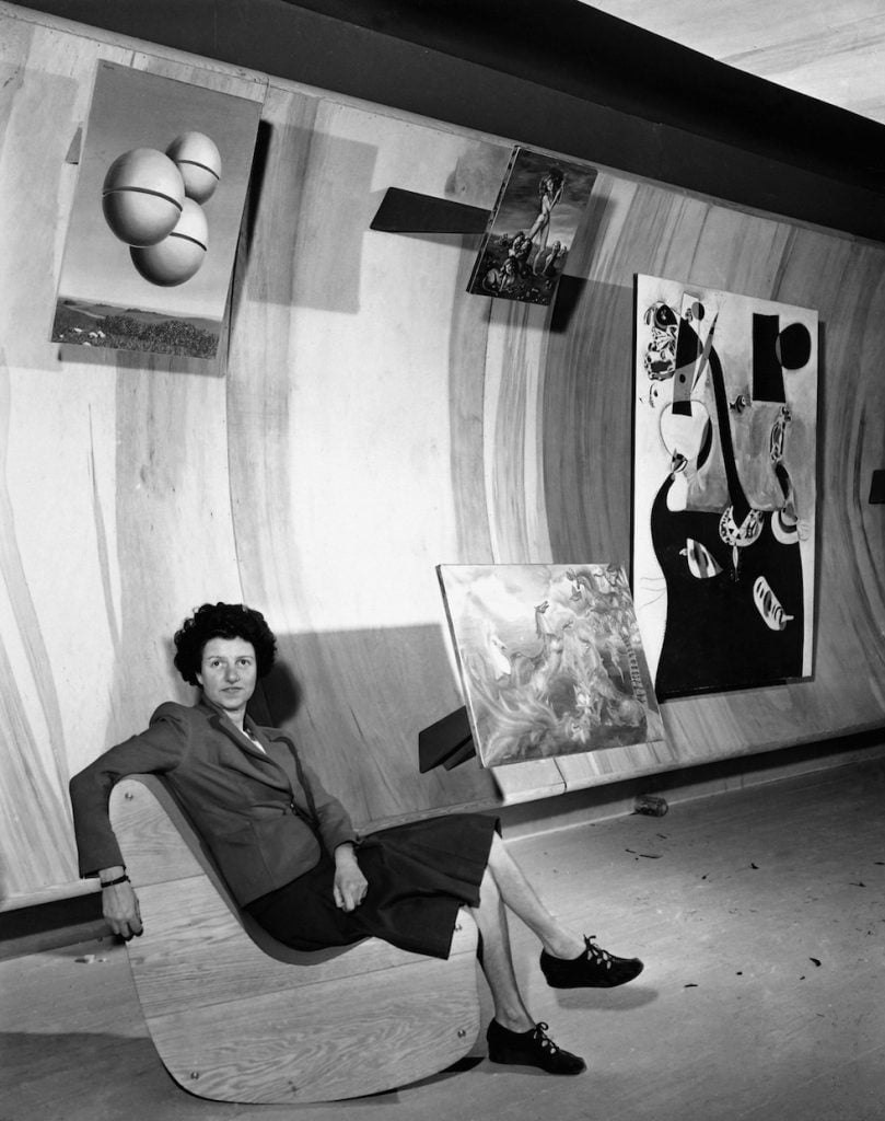 Art collector Peggy Guggenheim poses with paintings at the Museum of Modern Art in New York City, Oct. 22, 1942. (AP Photo)
