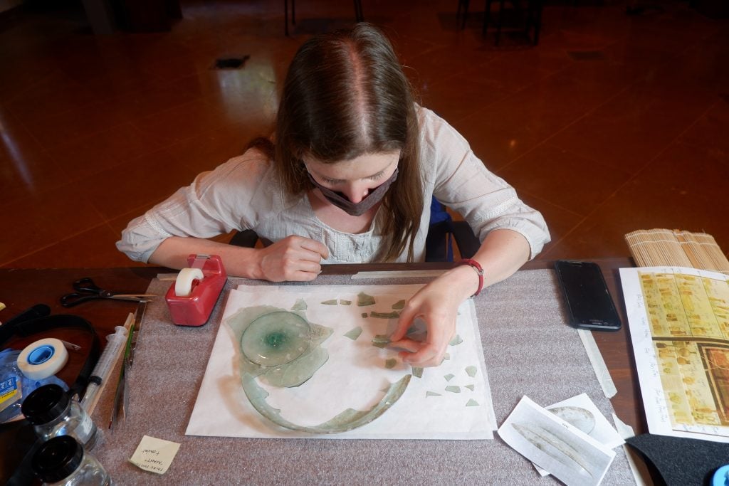 Conservator Claire Cuyaubère assisting with 
