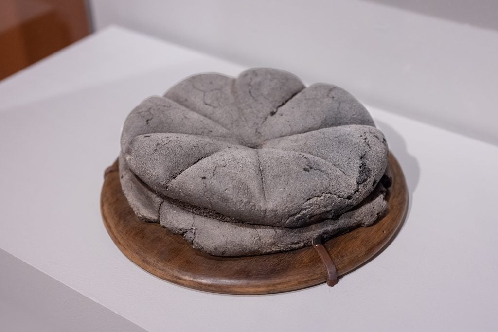 A carbonized loaf of bread in "Last Supper in Pompeii: From the Table to the Grave" at the Legion of Honor, San Francisco. Photo by Gary Sexton, courtesy of the Fine Arts Museums of San Francisco.