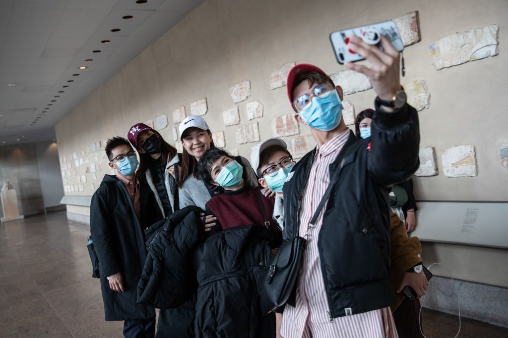 NEW YORK, NY - MARCH 12: Tourists wearing a protective mask take a selfie at the Metropolitan Museum of Art on March 10, 2020 in New York City on March 12, 2020 in New York City. The museum announced it will be closed Friday because of the COVID-19 pandemic. (Photo by Jeenah Moon/Getty Images)