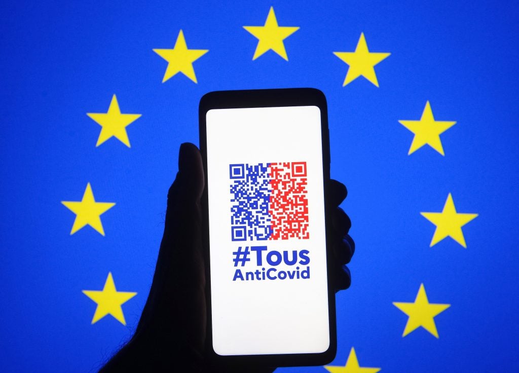 The TousAntiCovid app is seen on a smartphone with the EU flag in the background. The app's COVID-19 health pass, showing PCR tests, antigen tests, and vaccination certificates, is becoming mandatory for entrance to venues that host more than 50 people, including museums. Photo by Pavlo Gonchar/SOPA Images/LightRocket via Getty Images.