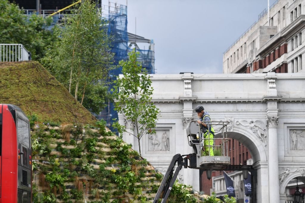 xA worker puts the finishing touches to the Marble Arch Mound, a new temporary attraction, next to Marble Arch in central London on July 25, 2021. Photo by Justin Tallis/AFP via Getty Images.