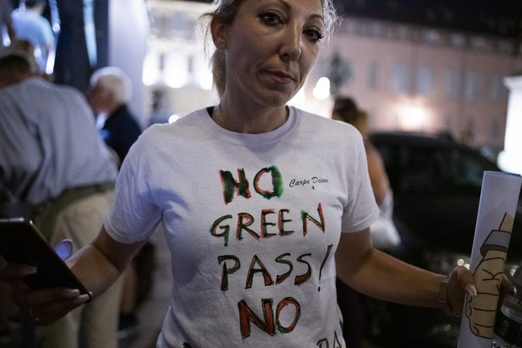 A demonstrator holds a No Green Pass on t-shirt during the No Vax Protest on July 22, 2021 in Turin, Italy. Protest by No Vax or Free Vax against the introduction of a health pass, called a green pass by the Italian Government which will be mandatory to access swimming pools, gyms and sports halls, sports events, concerts, fairs and cultural venues including museums, cinemas, and theaters. Photo by Stefano Guidi, Getty Images News. 