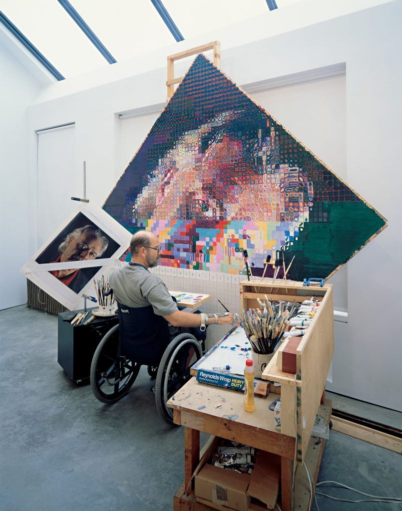 Chuck Close painting in his studio. Photo courtesy of Pace Gallery. 